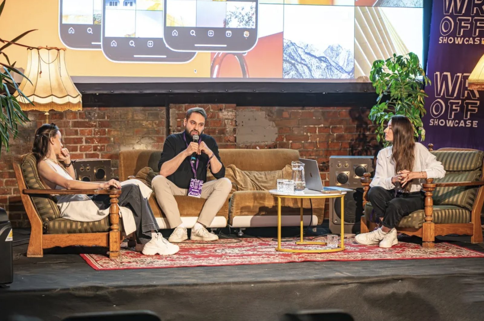 Jakub Żywuszko on a panel at a design conference, holding a microphone