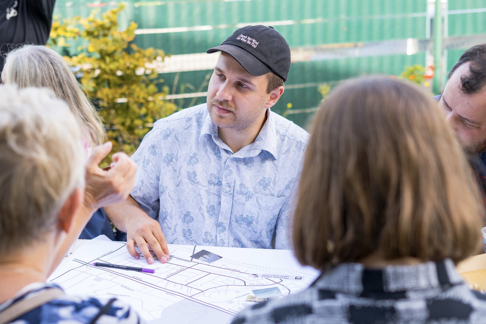 Workshop participant facilitating a group conversation around a shared map.