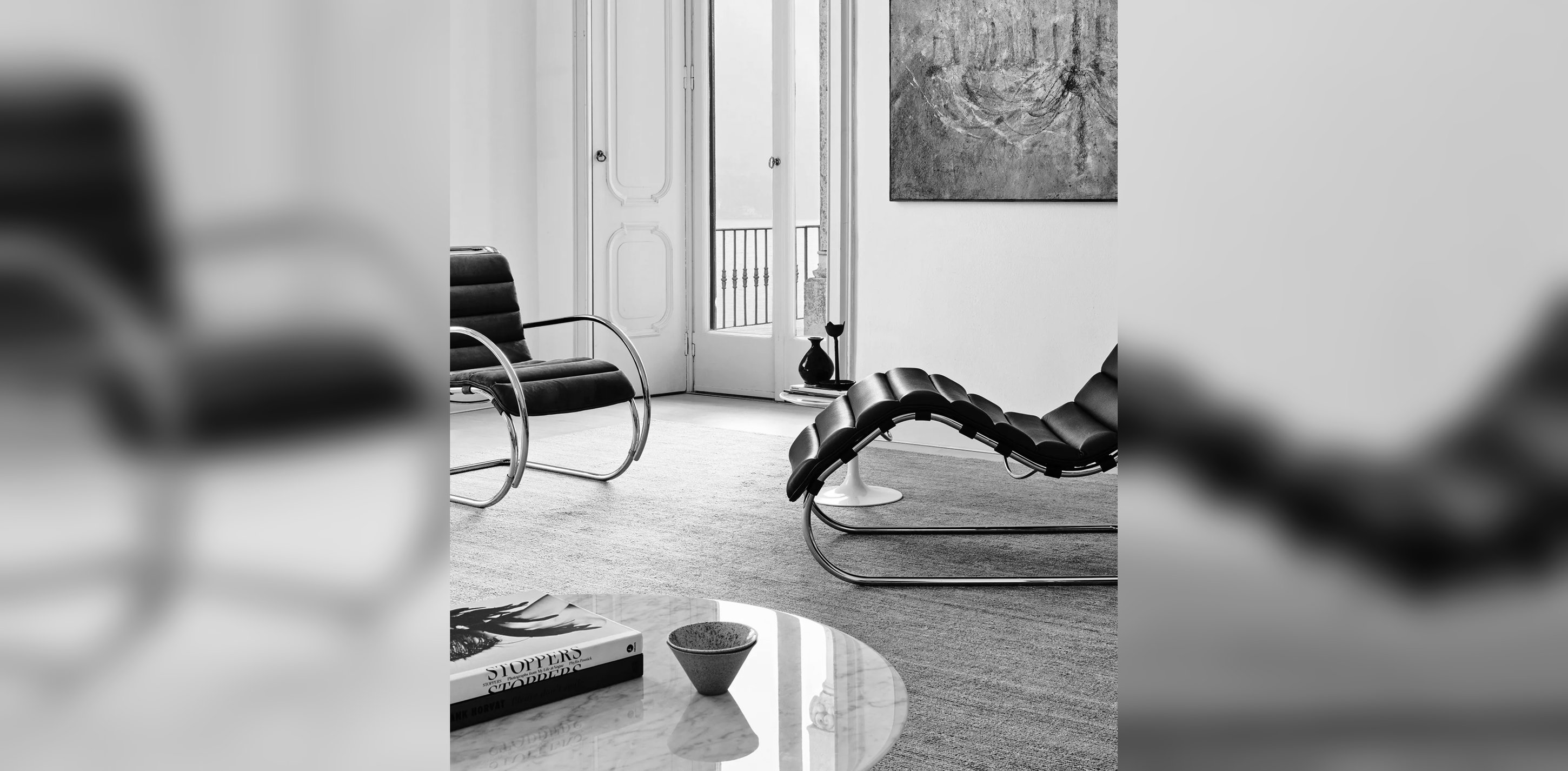 Black-and-white interior with a Bauhaus chaise longue and tubular steel chair.