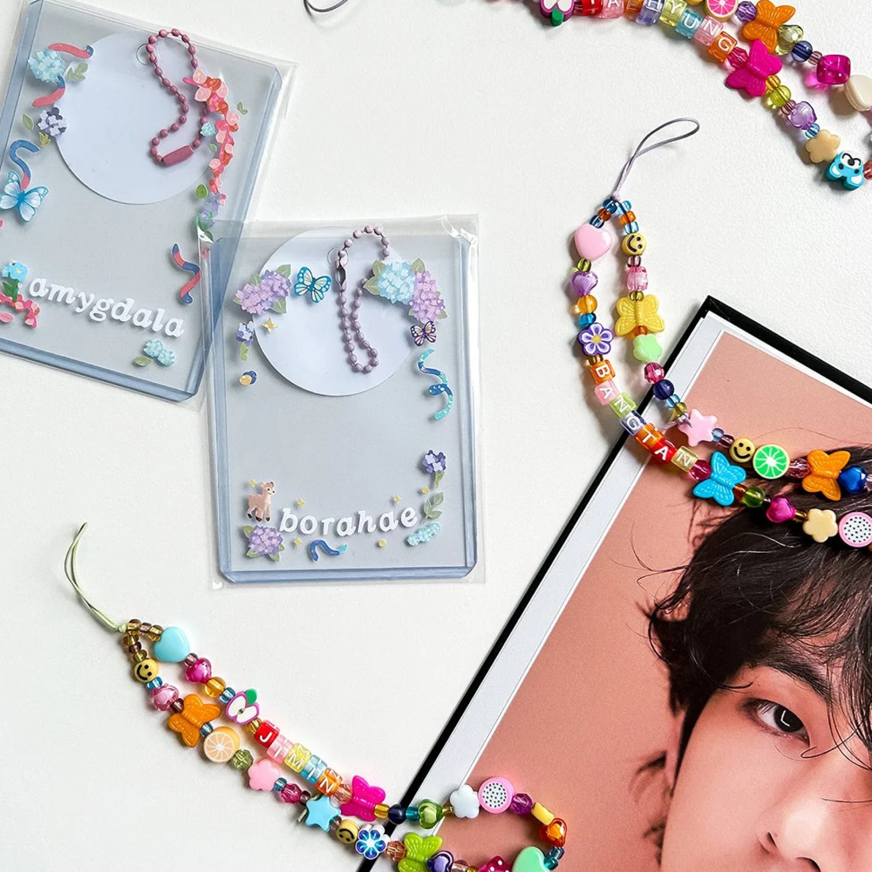 Beaded phone straps photographed over a magazine spread.
